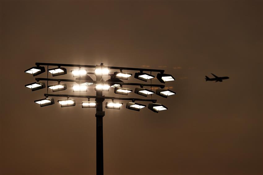 Floodlights bronze sunset and airplane